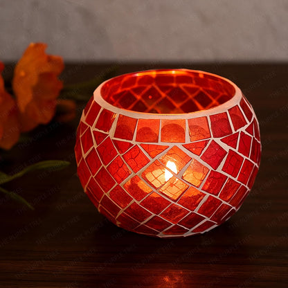 Two red glass tealights glowing on a table