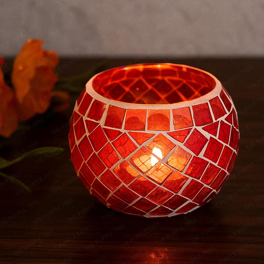 Two red glass tealights glowing on a table