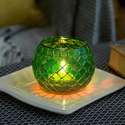 Green mosaic candle holder on a white plate with a blurred background