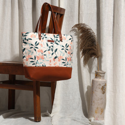Fashionable tote bag with floral design and brown leather handle, ideal for everyday use.