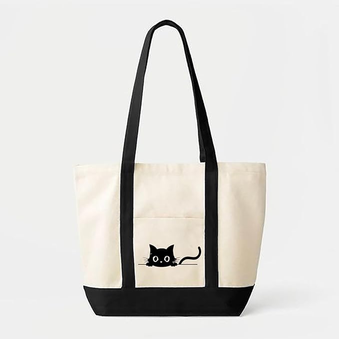 The front of a white tote bag showcases a black cat, emphasizing the contrast between the dark fur and light material.