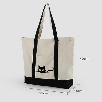  A black cat rests on the front of a white tote bag, providing a bold visual contrast with its dark color against the white.

