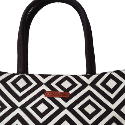 Trendy black and white bag containing a book and a glass of water.