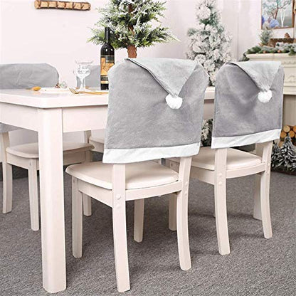 A festive scene with a table and four chairs adorned with a Christmas tree, creating a warm and inviting atmosphere.