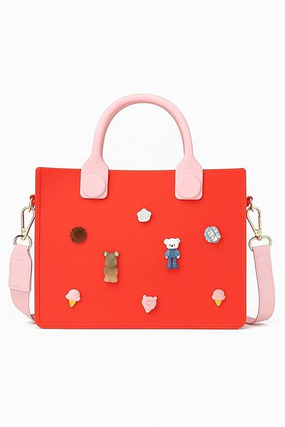 Red handbag with pink handles and decorative pins on a white background