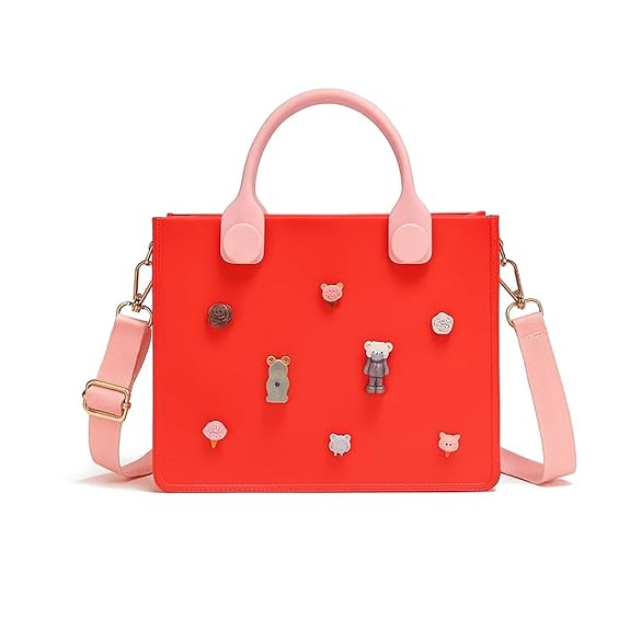 Red handbag with pink handle and strap, featuring small animal-shaped decorations on a white background.