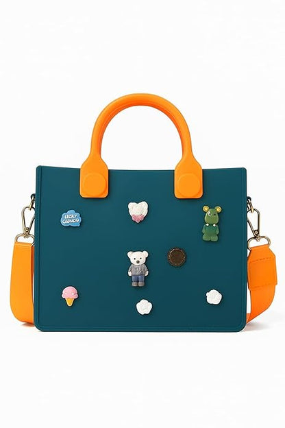 Teal handbag with orange handles and various colorful pins on a white background