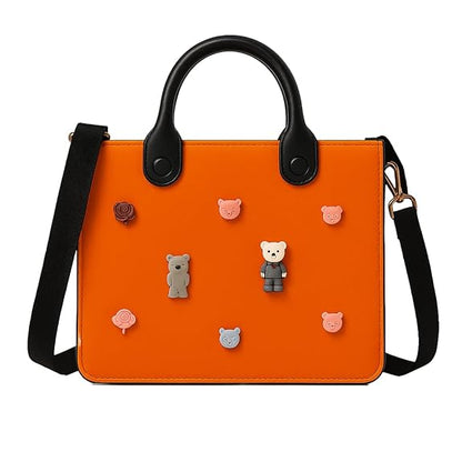 Orange handbag with black handles and a strap, featuring small bear-shaped decorations on a white background.