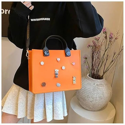 Person holding an orange handbag with decorative elements, wearing a black jacket with 'WINTERDREAMER' text.