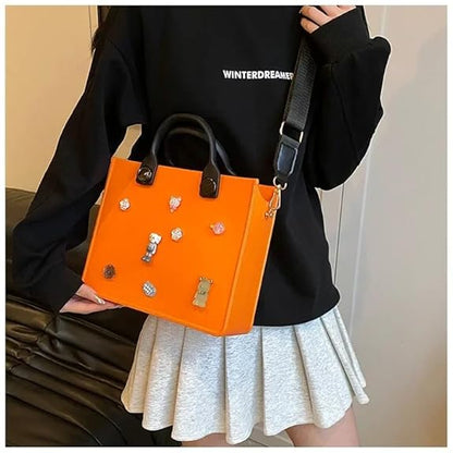 Person holding an orange handbag with decorative elements against a neutral background