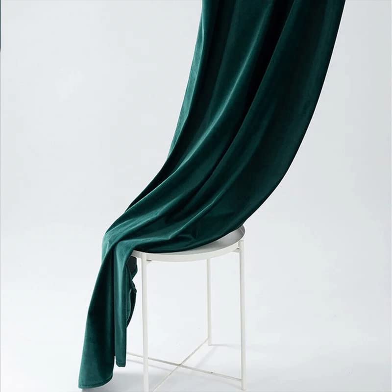 White vase placed near a dark green curtain.