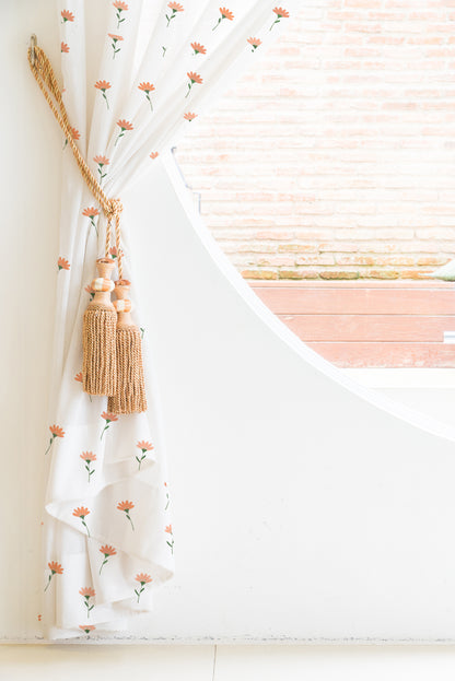 A white curtain adorned with vibrant orange flowers, adding a touch of elegance and warmth to any space.