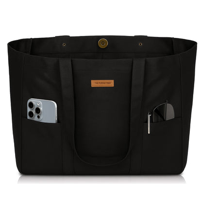 Black tote bag with pockets and a phone inside on a white background