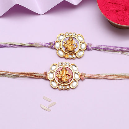 Two gold and purple rakhi with a flower, traditional Indian bracelets for celebrating Raksha Bandhan.