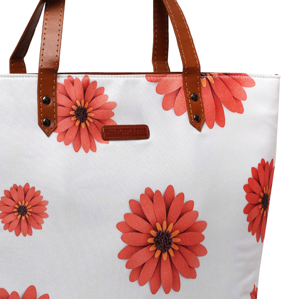 A tote bag adorned with vibrant orange flowers, adding a touch of elegance and charm.