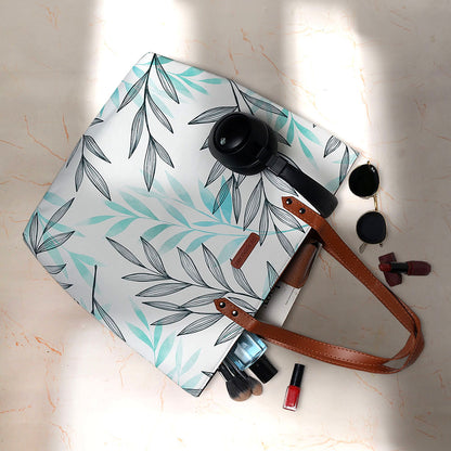 Chic tote bag with white and green leaf design, ideal for adding a touch of nature to your outfit.