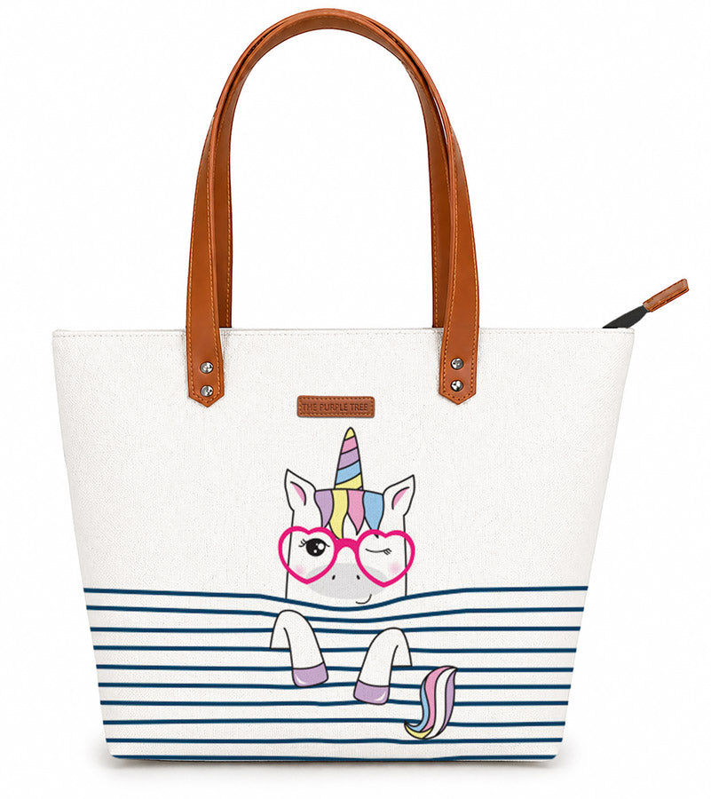 White tote bag with a unicorn design and brown handles on a white background