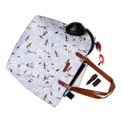Stylish tote bag featuring floral print design and durable leather handles.
