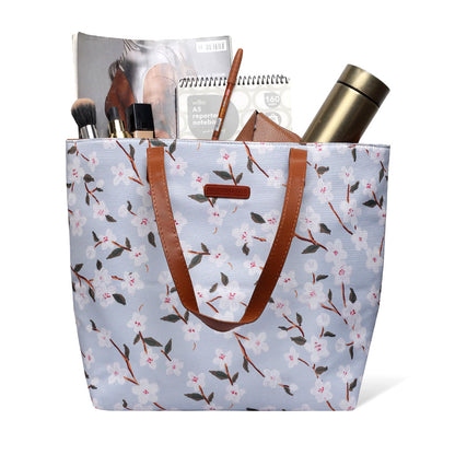 Floral print tote bag with leather handles, perfect for carrying essentials in style.