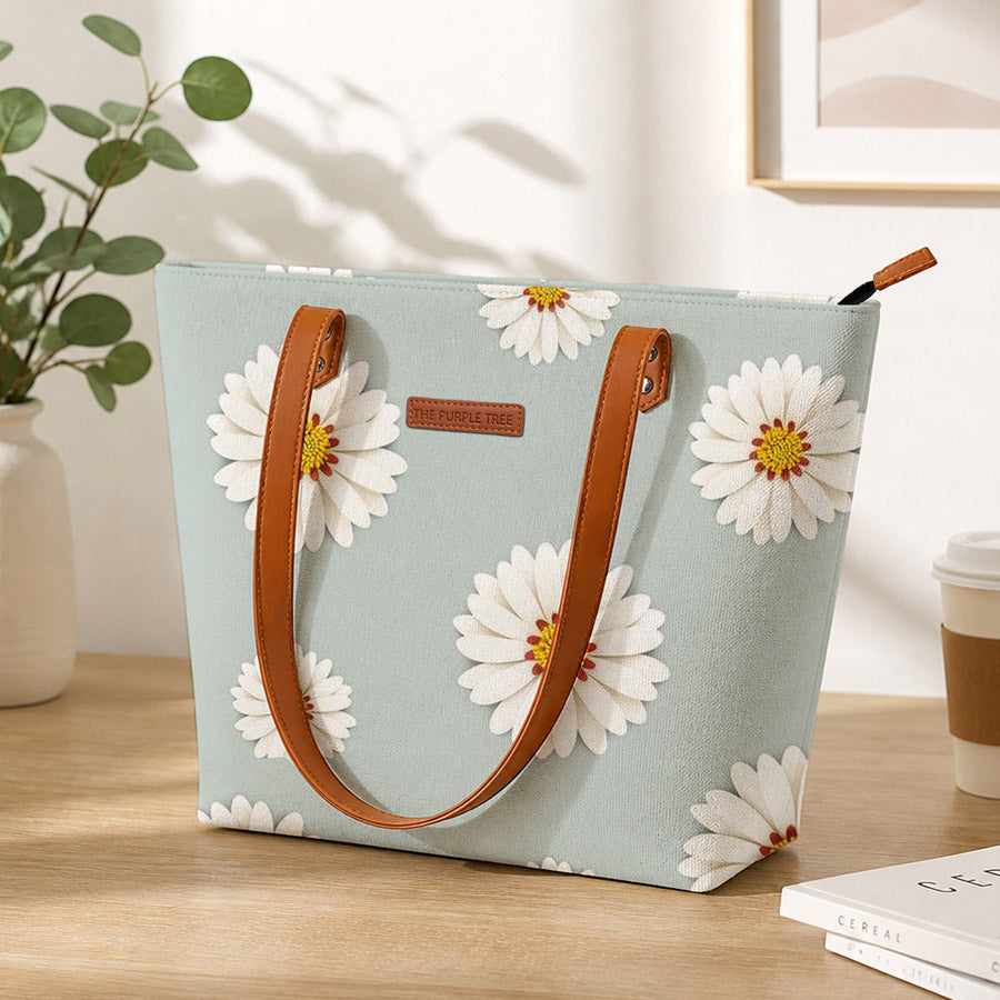 Light blue tote bag with white floral patterns on a wooden surface.