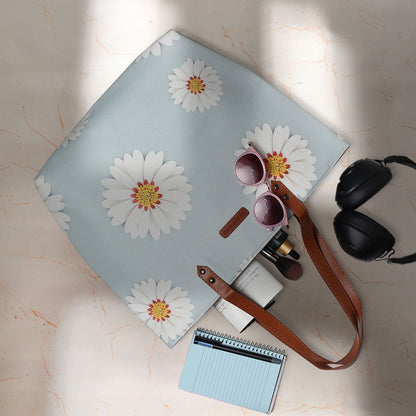 Add a pop of floral flair to your look with this roomy tote bag showcasing pretty white daisies.