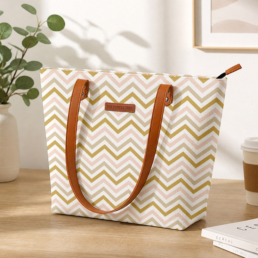 A stylish tote bag with a pink and gold chevron pattern, perfect for adding a touch of elegance to any outfit.