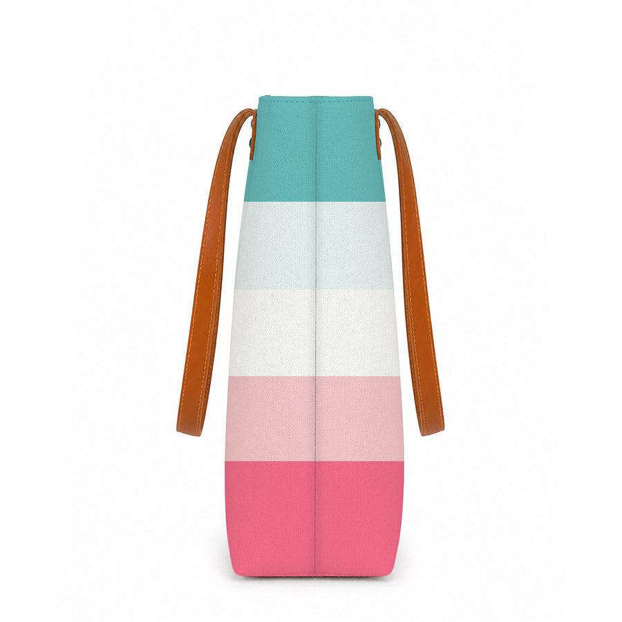 A stylish tote bag with pink, blue, and white stripes, perfect for carrying essentials on a sunny day out.