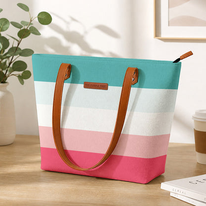A stylish tote bag with pink, blue, and white stripes, perfect for carrying essentials on a sunny day out.