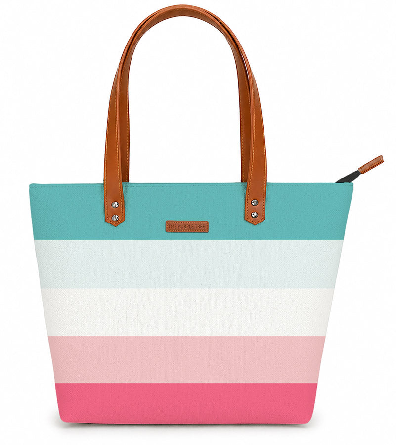 A stylish tote bag with pink, blue, and white stripes, perfect for carrying essentials on a sunny day out.