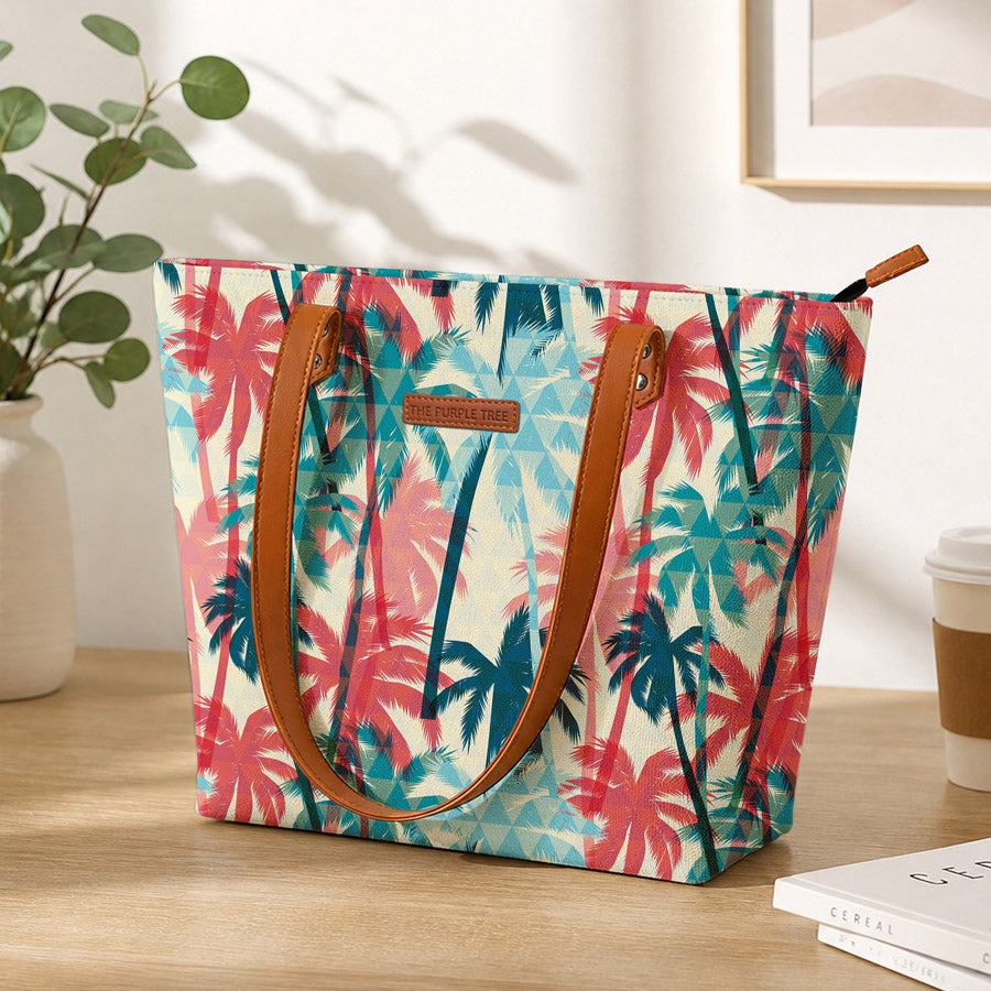 Tropical patterned bag on a wooden surface with a plant and coffee cup in the background