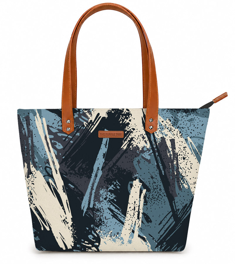 Tote bag with abstract design and brown handles on a white background