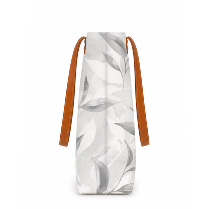 White large tote bag with leaf pattern and brown straps on a white background