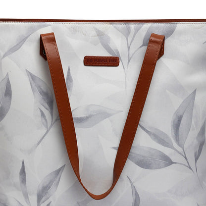  White and gray leaf print tote bag on a wooden table.