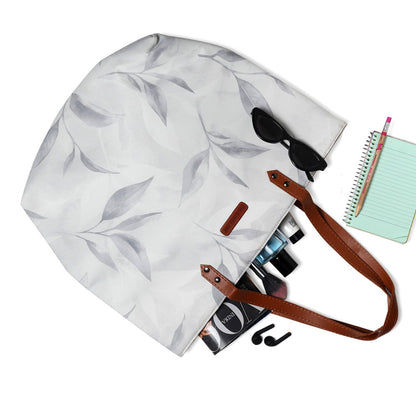 An elegant tote bag adorned with a white and gray leaf pattern.