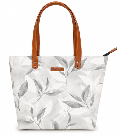 Tote bag with leaf pattern and brown handles on a white background