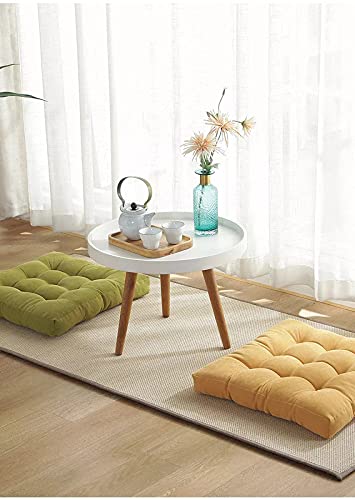 A white table with a yellow and green cushion.