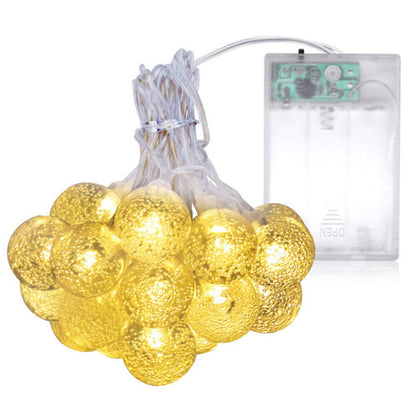 A string of battery-powered Christmas lights glowing against a dark background.