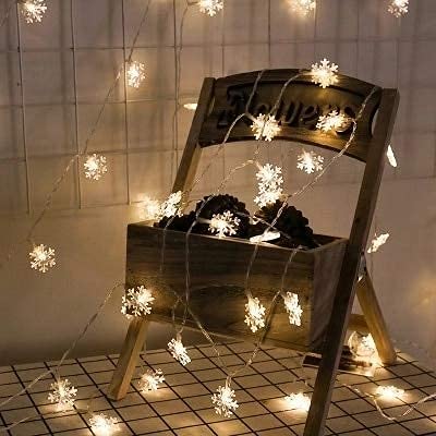 Glowing snowflake LED Christmas lights bringing a festive glow to the winter landscape.