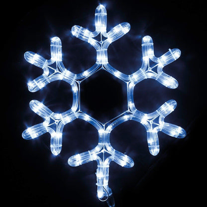 A glowing snowflake illuminated against a dark black background, creating a striking contrast and festive atmosphere.
