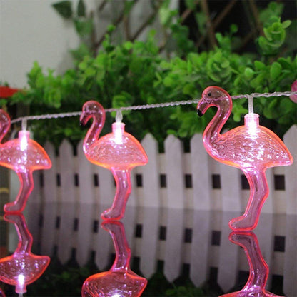 A line of flamingos elegantly decorated with pink lights, adding a touch of color and cheer to the environment.
