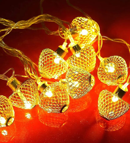 A warm display of golden heart-shaped string lights illuminating a cozy space with a romantic ambiance.