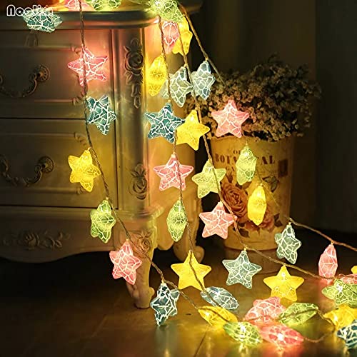 A tranquil space with a bed, a lamp, and a table highlighted by a lovely star garland.