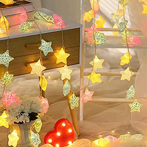 Cozy room featuring a bed, a lamp, and a table adorned with a decorative star garland.
