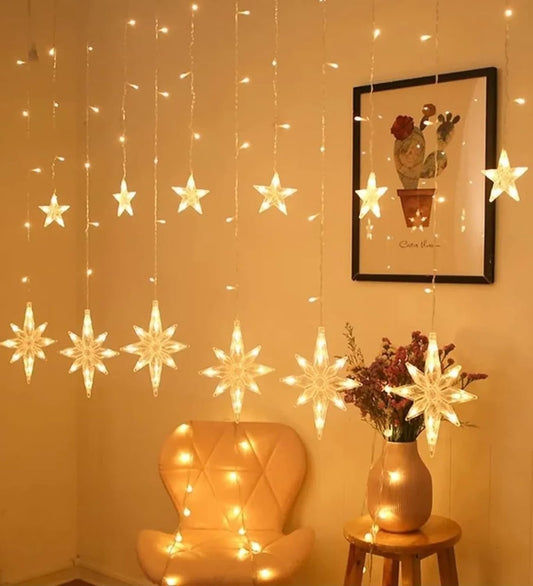 Festive window display featuring star-shaped decorations and twinkling lights, adding a touch of magic.