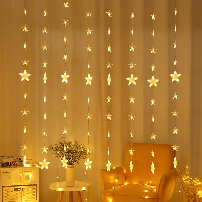  Chair and curtain in a room, bathed in warm light from twinkling bulbs.