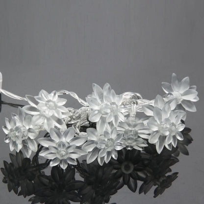 White floral decorations on a holiday tree.