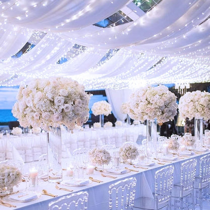 Beautiful white curtain illuminated by twinkling lights, creating a cozy atmosphere.