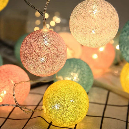 Vibrant ball string lights creating a cheerful atmosphere when hung on a wall.