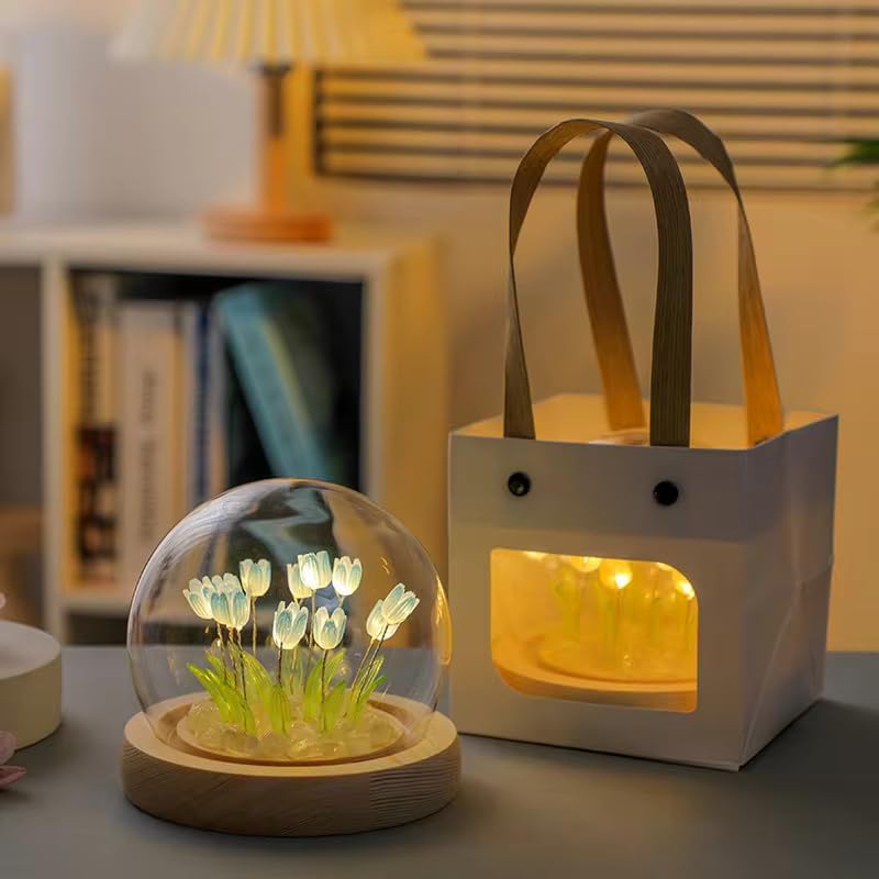 A glass globe containing vibrant flowers, accompanied by a stylish bag, creating an elegant display of nature and fashion.