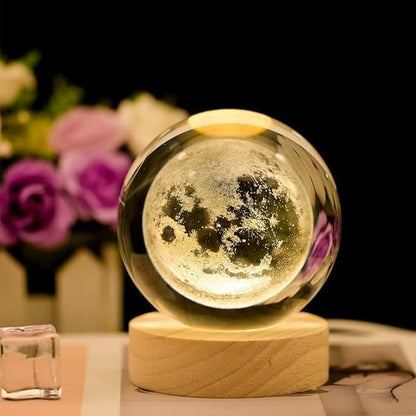 A moon ball resting on a table surrounded by colorful flowers, creating a serene and whimsical atmosphere.